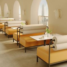 a room filled with lots of white couches and yellow tables in front of windows