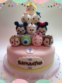 a pink cake topped with lots of small figurines