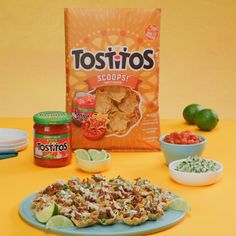 tacos, chips and salsa on a table next to a bag of tortillas