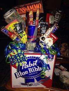 a blue ribbon wrapped gift box filled with candy and candies for someone's birthday