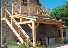 an outdoor kitchen with stairs leading up to the top floor and above it is a stone building