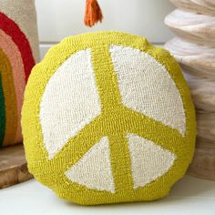 two decorative pillows with peace signs on them, one is yellow and the other is red