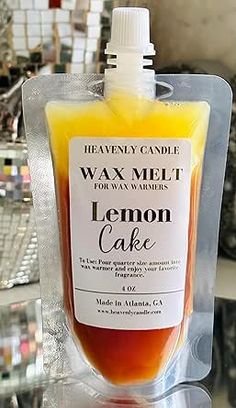 a bottle of wax melt sitting on top of a plastic bag filled with lemon cake