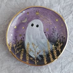 a purple and gold plate with a white ghost on it