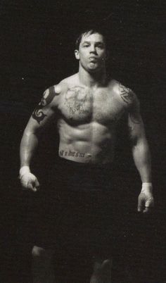 a shirtless man standing in the dark with his hands on his hips and looking at the camera