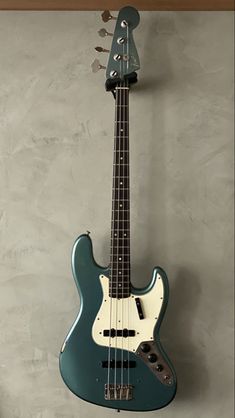 an electric bass guitar hanging on the wall