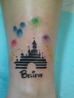 a tattoo on the foot of a person with a castle and fireworks in the background