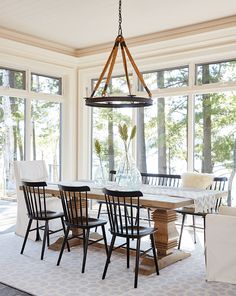 a dining room table with chairs and a chandelier hanging from it's ceiling