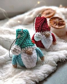 two small crocheted gnomes sitting on top of a white fur covered floor