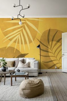 a living room with yellow wallpaper and large palm leaves painted on it's walls