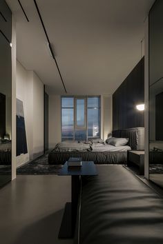 a modern bedroom with black leather furniture and large windows