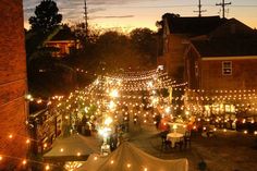 an outdoor event with lights strung from the ceiling