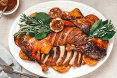 a white plate topped with sliced up turkey and garnished with fresh herbs next to a cup of tea