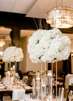 the centerpieces are filled with white flowers and candles