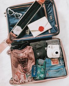 an open suitcase filled with clothing and accessories