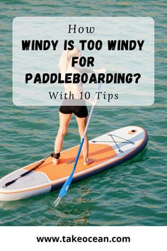 a woman standing on top of a paddle board in the water with text overlay reading how wind is too windy for paddling with 10 tips