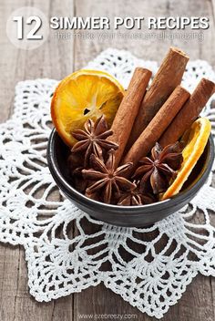 a bowl filled with cinnamons, orange slices and star anise on top of a doily