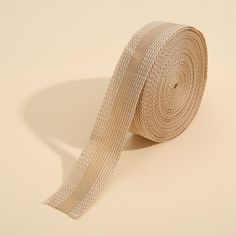 a roll of white sheer ribbon on a beige background