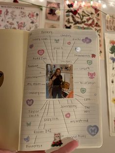 a person holding an open book with pictures on the pages and writing words in it