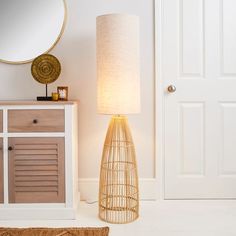 a lamp that is sitting next to a cabinet and door with a mirror on it