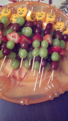 grapes, kiwis and strawberries are arranged on a platter with smiley faces