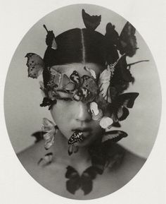 a black and white photo of a woman with butterflies on her head