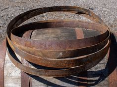 three old wooden barrels stacked on top of each other in the middle of an outdoor area