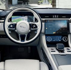 the interior of an electric vehicle with its dashboard and infotains showing, in front of a house