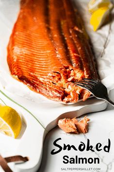 smoked salmon on a white plate with lemon wedges