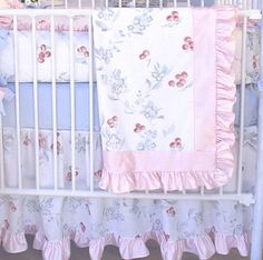 a baby crib with pink and blue bedding