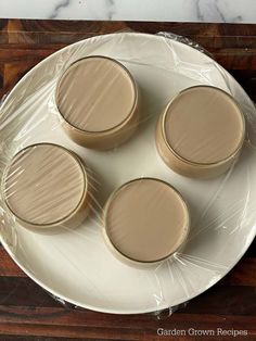 four brown cups sitting on top of a white plate