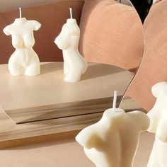 three white candles sitting on top of a table