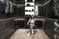 a woman sitting on a chair in a closet