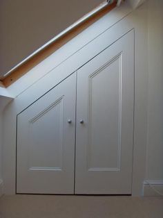 an attic bathroom with white cabinets and a skylight above the bathtub is seen in this image