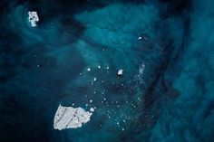 an aerial view of the ocean with ice chunks floating in it and some blue water