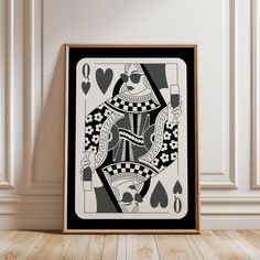 a black and white ace playing card on a wooden floor in front of a wall