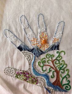 a close up of a piece of cloth with an embroidered tree and sun on it