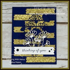 a blue and gold card with some flowers on it, the words thinking of you are written