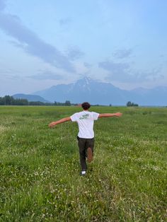 a man in a field with his arms outstretched