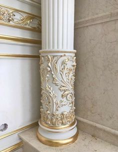 a white and gold pillar in the corner of a room