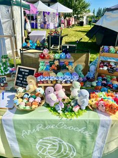 there are many stuffed animals on display at this outdoor market stall that is set up for sale