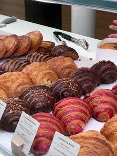 there are many croissants and pastries on display