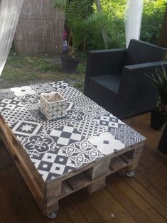 a coffee table made out of pallet wood with black and white tiles on it