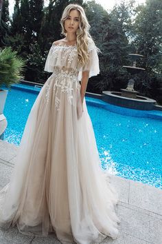 a woman standing in front of a pool wearing a dress