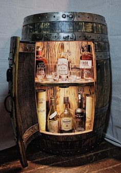 an old wooden barrel filled with liquor bottles