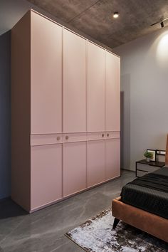 a bedroom with pink cabinets and a black bed