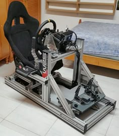 a car seat sitting on top of a metal frame in a room with a bed