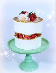 a white cake with strawberries and flowers on top is sitting on a green plate