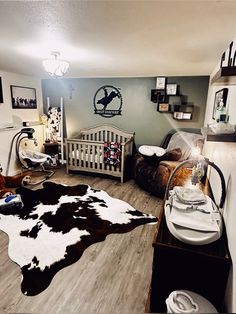 a baby's room with a cow skin rug on the floor and other furniture