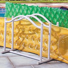 an inflatable banana float is next to a swimming pool with plastic bags on it